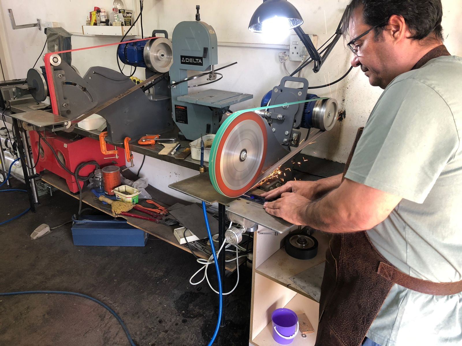 Grinding a blade blank on the belt grinder, sparks flying